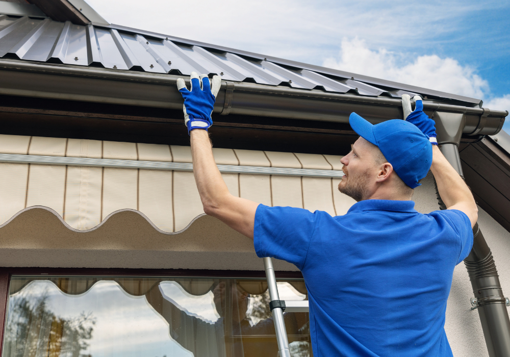 Worker installs metal roof with blue gloves.