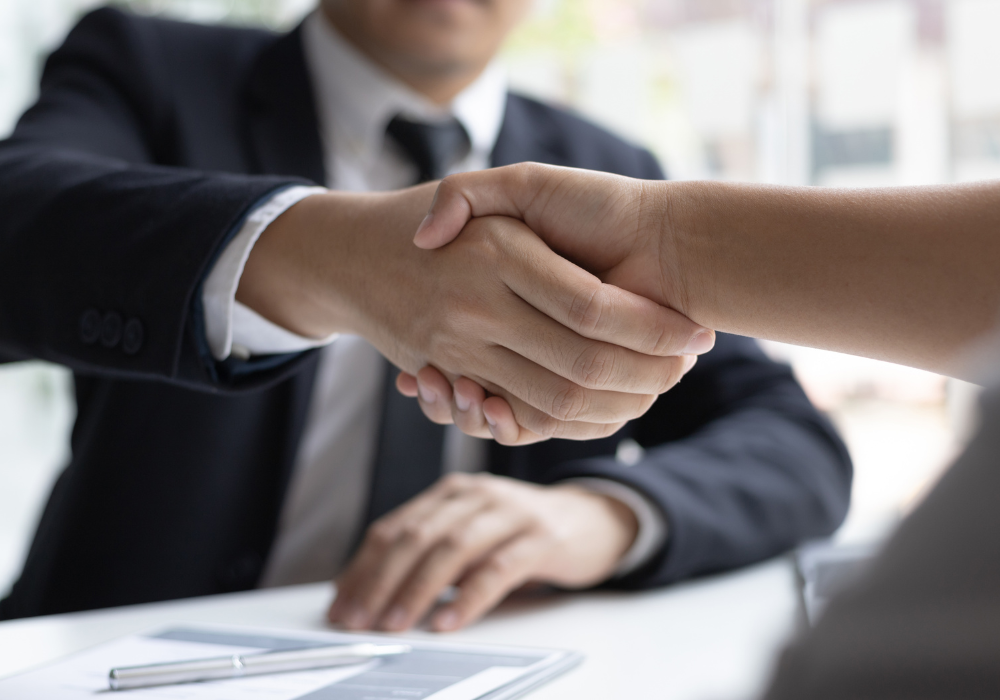 Business handshake agreement in office setting.